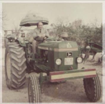 Foto de archivo: tractor John Deere de los primeros años de la empresa, con el conductor al volante
