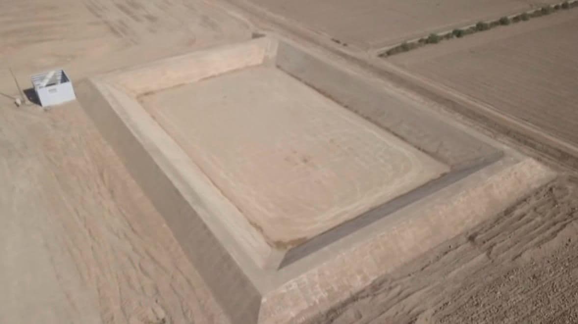 Vista aérea del vaso acabado, rectangular y con los cuatro taludes perfilados, y la caseta de riego junto a la pista de coronación