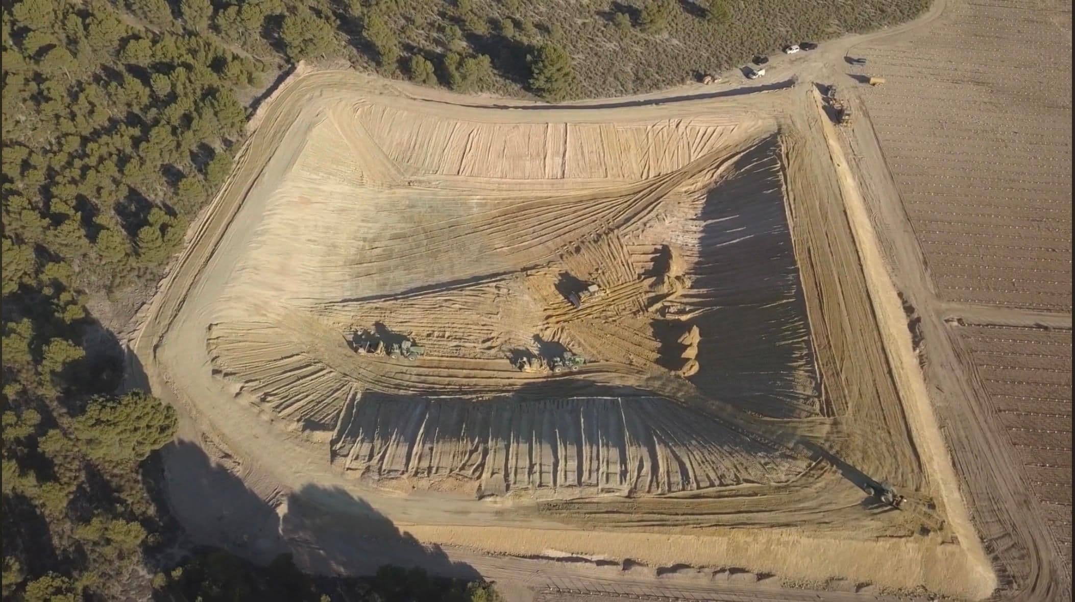 Cuatro máquinas alineadas en el fondo del vaso, con la pista de coronación cerrada alrededor y el pinar al borde