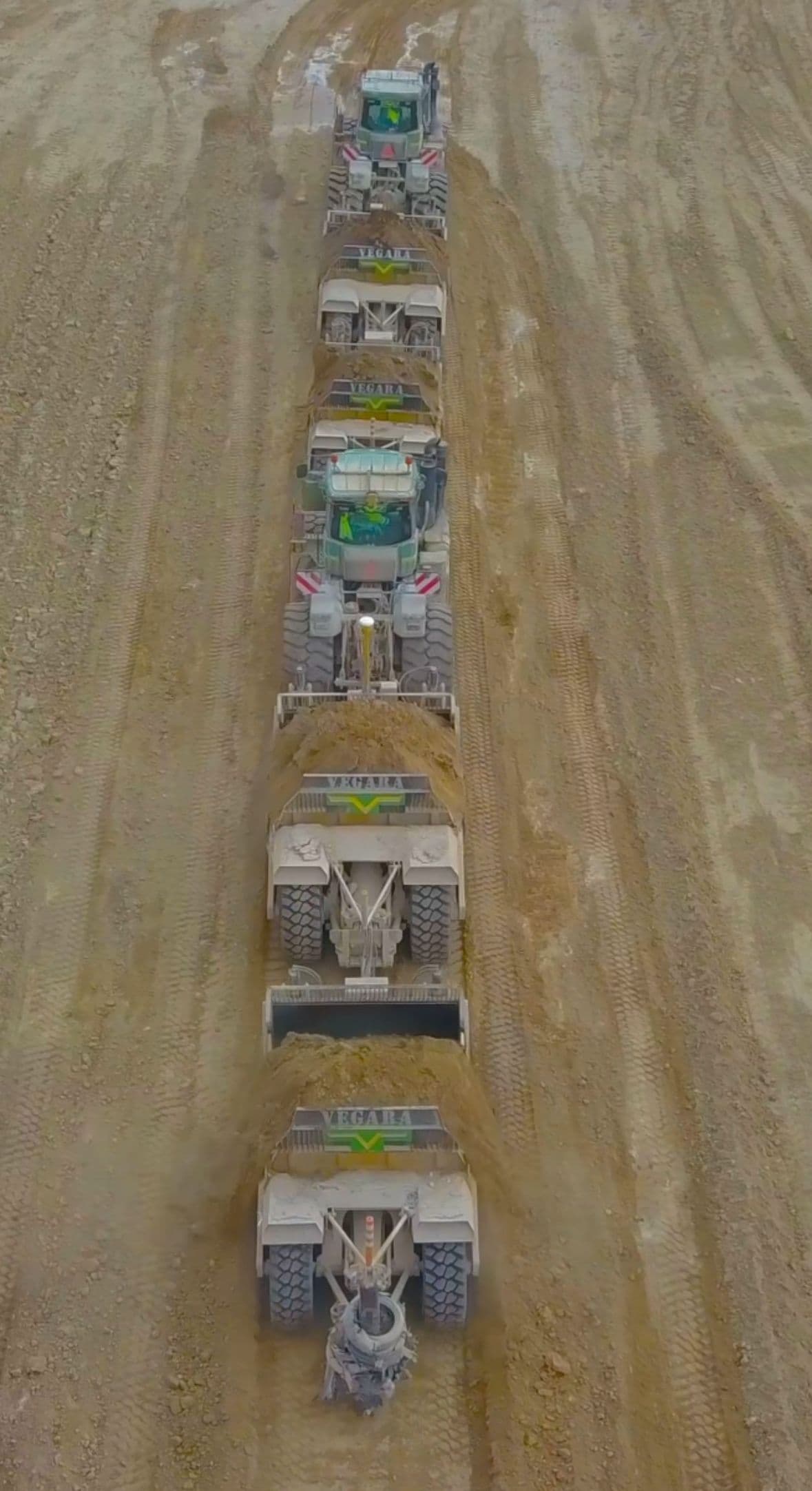 Vista aérea de una fila de traíllas de Vegara trabajando una tras otra dentro de la excavación